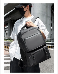 Detail of multi-compartment black travel backpack with waterproof nylon and side mesh pockets