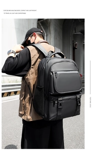 Outdoor back view of a large black travel backpack with multiple functional compartments