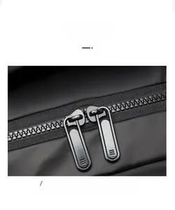 Detail of durable dual metal zippers with textured pullers on a black travel backpack