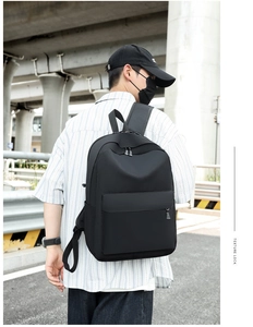 Detailed view of large black Oxford fabric backpack worn by a model in urban setting
