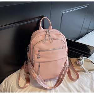 Detail eines rosa Rucksacks aus Kunstleder mit bestickten Trägern im Lifestyle-Design