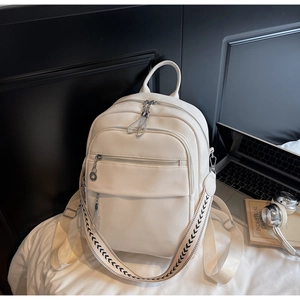 Detail eines weißen Lederrucksacks mit silbernen Reißverschlüssen und Web-Schultergurt