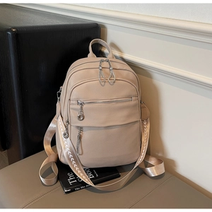 Detail of beige pebble leather backpack with fashion patterned strap and dual zippers