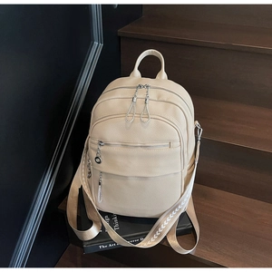 Nahaufnahme des beigen Rucksacks mit mehreren Reißverschlüssen und gemustertem Webband-Gurt