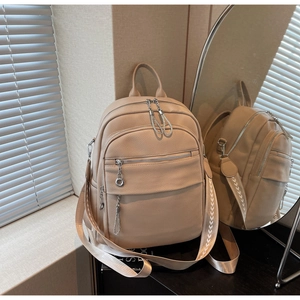 Detail eines beigen Lederrucksacks mit silbernen Beschlägen und gewebten Schultergurten
