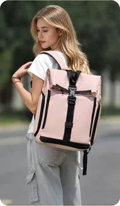 Pink roll-top backpack with industrial buckle worn by a female model on a city street