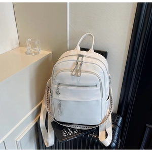 Detailansicht eines weißen Rucksacks mit Lychee-Struktur und gewebten Trägern