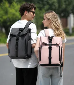 Detailed view of grey and pink roll-top backpacks with buckles on models outdoors
