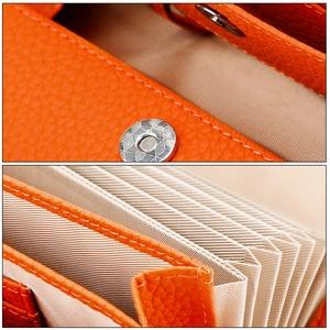 Close-up of orange pebble leather wallet with magnetic snap and accordion card slots