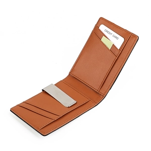 Detail of slim brown leather wallet showing stainless steel money clip and card slots