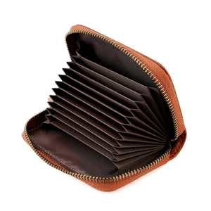 Detail of a brown leather accordion card holder with a metal zipper and multi-slot interior