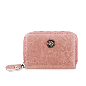 Detailed macro view of the vintage rose flower metal emblem on the pink leather wallet