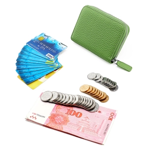 Detail view of green pebble leather card holder with cards and coins for storage capacity