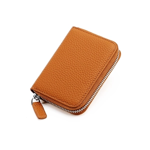 Detail of genuine brown leather wallet showing high-quality lychee texture and metal zipper