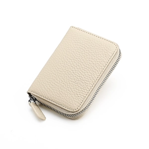 Detailed macro view of the cream-colored lychee leather texture and metal zipper