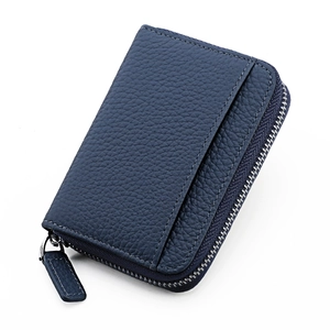 Close-up of navy blue pebbled leather wallet showing stitching and silver zipper detail