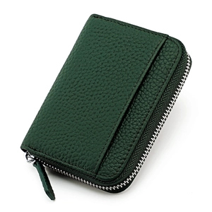 Detailed macro view of forest green pebble grain leather wallet with metal zipper closure