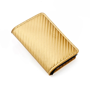 Macro detail of golden business card holder featuring carbon fiber texture and fine stitching