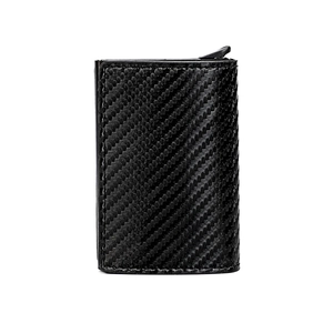 Close-up of black carbon fiber texture and ejector button on aluminum wallet card holder