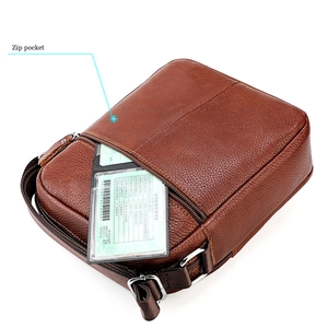 Détail du sac bandoulière en cuir marron grainé montrant la poche zippée fonctionnelle
