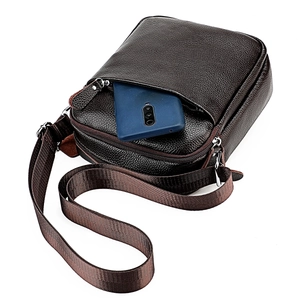 Detail of dark brown pebble leather messenger bag showing front pocket phone storage