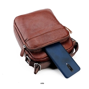 Vue détaillée du sac en cuir marron montrant les poches zippées et le compartiment mobile