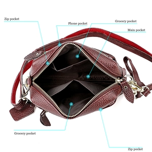 Détail de l'intérieur d'un sac en cuir bordeaux avec compartiments zippés pratiques