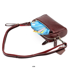 Détail de la texture cuir litchi bordeaux et des fentes pour cartes de ce mini sac à bandoulière