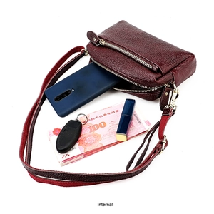 Vue de dessus du sac en cuir bordeaux montrant le double rangement zippé et détails