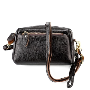 Détail de la texture cuir grainé et fermeture éclair dorée sur le petit sac bandoulière