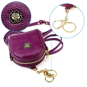 Detail der violetten Mini-Tasche aus Leder mit Rosengold-Logo und Metall-Karabiner