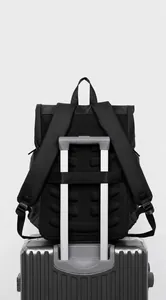 Detail showing the travel backpack back sleeve secured on a silver suitcase handle