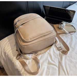 Details des beigen Rucksacks aus strukturiertem Leder mit gewebtem Schultergurt
