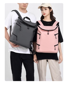 Detail of grey and pink waterproof nylon backpacks with side and bottom zipper compartments