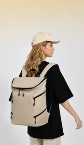 Detail view of large capacity beige travel backpack with multiple black zipper compartments