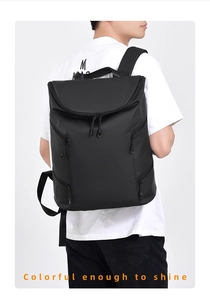 Rear view of model wearing a matte black waterproof backpack with multi-zipper layers