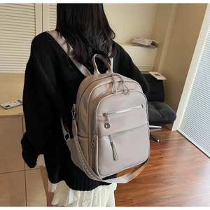 Detail des apricotfarbenen Kunstleder-Rucksacks mit Metallkette und Fransen-Reißverschluss