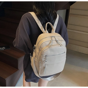 Detail des beigen Rucksacks mit Lychee-Struktur und silbernen Ketten-Reißverschlüssen