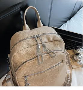 Detail of apricot pebbled leather backpack showing smooth silver zippers and layered pockets