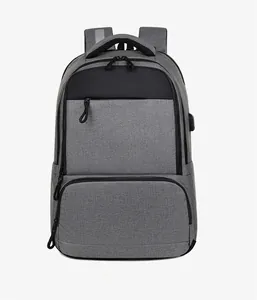 Detail of grey business backpack showing USB charging port and reflective safety strips