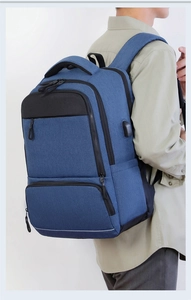 Blue business backpack side view featuring a USB charging port and safety reflective strip