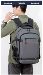 Vista lateral de mochila gris grande con múltiples compartimentos y correas ergonómicas