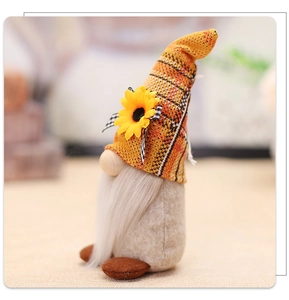 Detailed close-up of a knitted harvest gnome doll featuring a yellow sunflower and long beard