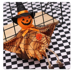 Macro shot of Halloween ghost doll featuring a pumpkin head, witch hat and spiderweb cloak