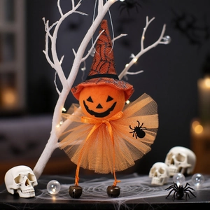 Halloween hanging pumpkin witch with mesh skirt and bells on a spooky decorative tree