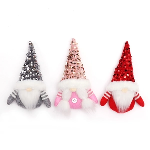 Three Christmas gnomes with sequined hats and long white beards on a white background