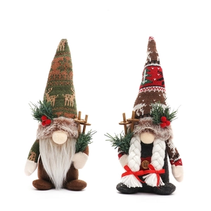 Pair of Christmas gnome plush dolls with knitted hats and wooden sled poles on white background