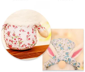 Detail display of floral fabric Easter gnomes with plush rabbit ears and wooden base