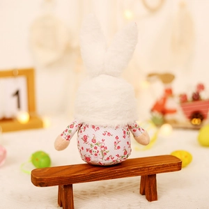 Easter bunny plush with floral pattern on a wooden bench for festive home decoration