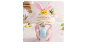 Close-up of Easter gnome plush with pink bunny ears holding a blue striped egg decor